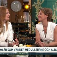 Anna Stadling and Helen Sjöholm in white clothes beeing interviewed in the TV4 studio.