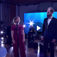Photo: Helen Sjöholm and Fredrik Lycke in TV¤ Nyhetsmorgon, singing in blue light.