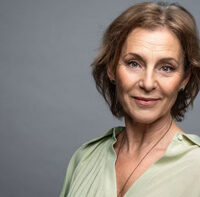 Helen Sjöholm i ljusgrön blus mot grå bakgrund. Foto och © Nicola Stankovic